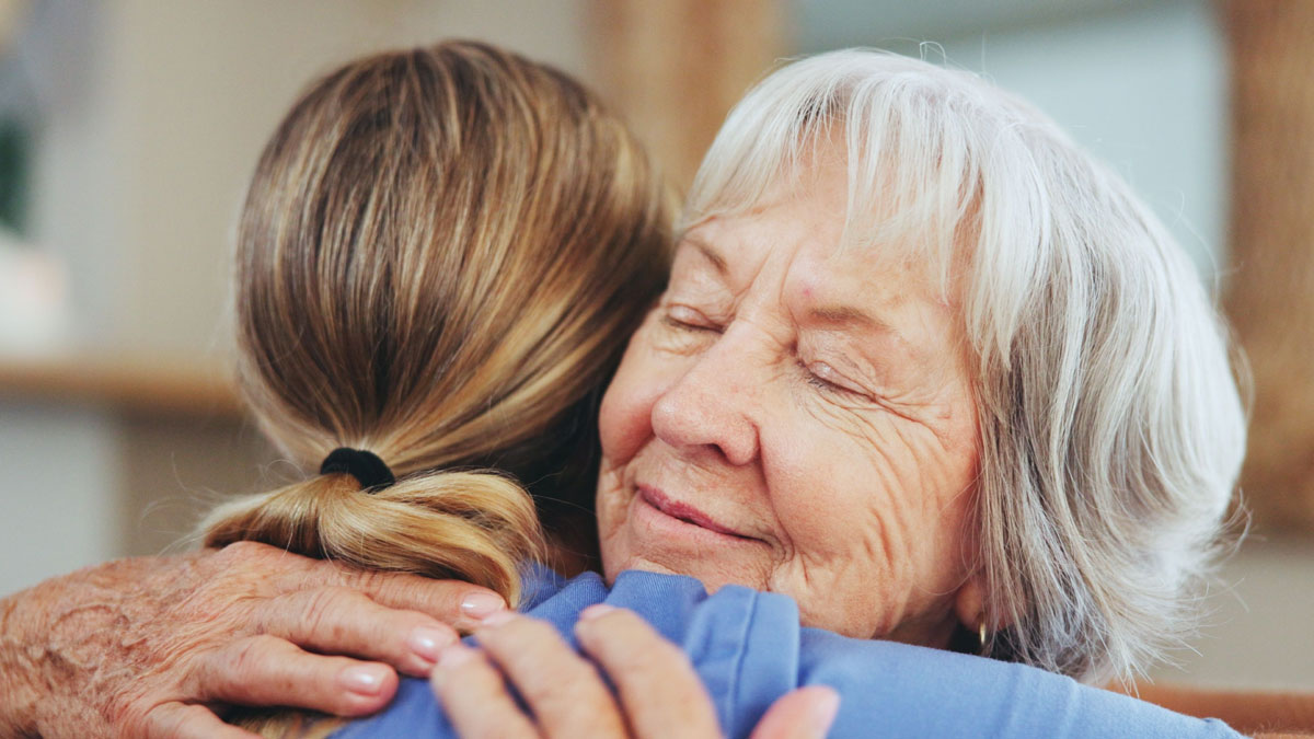 A senior woman hugging a caregiver